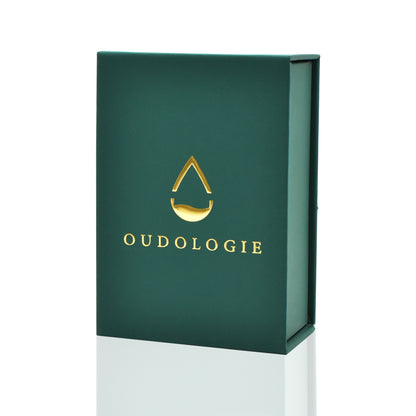 Closed dark green Oudologie oud oil presentation box featuring an elegant gold logo.